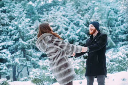 Cute young hipster couple having fun in winter parkの写真素材