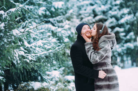 Cute young hipster couple having fun in winter parkの写真素材