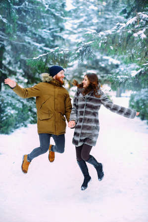 Cute young hipster couple having fun in winter parkの写真素材