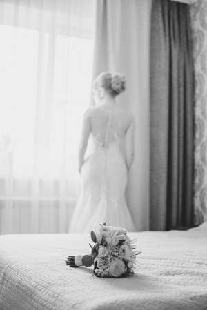 Beautiful bride in white dress posing on preparations. Black and white photoの写真素材
