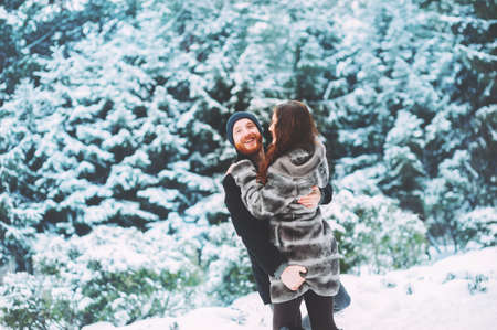Cute young hipster couple having fun in winter parkの写真素材
