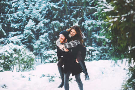 Cute young hipster couple having fun in winter parkの写真素材