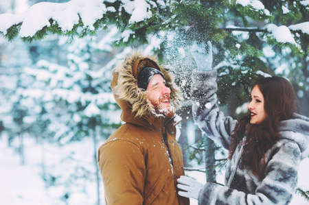 loving couple having fun in the snowy forestの写真素材