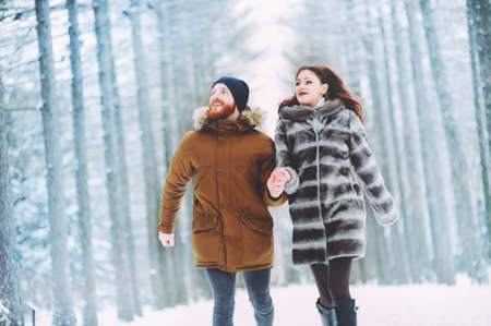 Guy and girl walk ,have fun in the forest in winterの写真素材