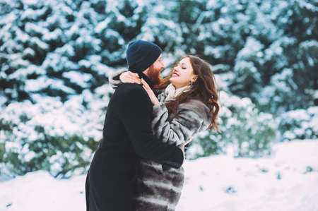 Guy and girl walk and have fun in the forest in winterの写真素材