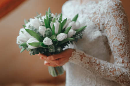 bride with a beautiful bouquet of different flowers in the hotelの写真素材