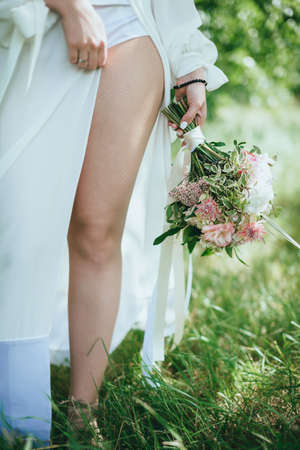 bride in nature with a beautiful wedding bouquetの写真素材