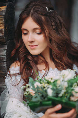 portrait of a beautiful bride against the background of a wooden houseの写真素材