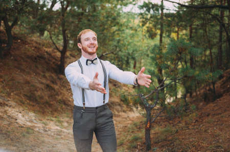 Hipster. Stylish groom with beard posing outdoorsの写真素材