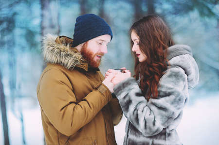 People, season, love and leisure concept - happy couple hugging and laughing outdoors in winter.の写真素材
