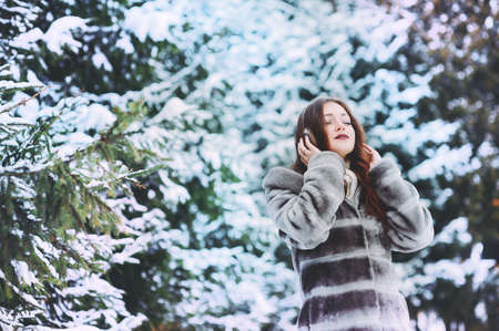 Happy Winter Woman With Headphones - Beautiful girl listening to music outsideの写真素材