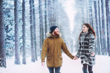 Guy and girl walk ,have fun in the forest in winter