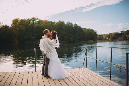 stylish bride and groom posing on the background of the riverの写真素材