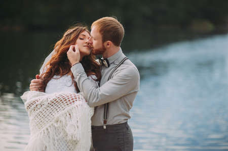 stylish bride and groom posing on the background of the riverの写真素材