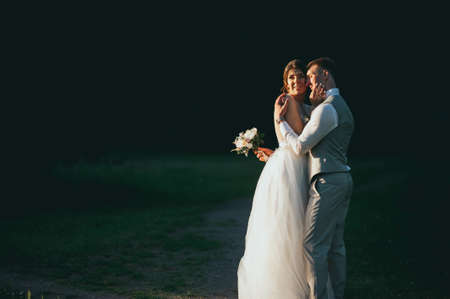 the bride and groom at sunset on a dark backgroundの写真素材