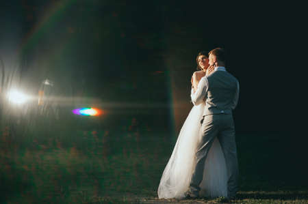 the bride and groom at sunset on a dark backgroundの写真素材