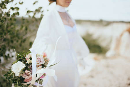 Beautiful portrait of bride with a bouquet in a flying dressの写真素材