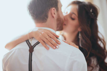 The groom and bride sitting against the background of a large window.の写真素材