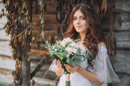 stylish beautiful bride with wedding bouquet in natureの写真素材