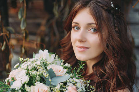 stylish beautiful bride with wedding bouquet in natureの写真素材
