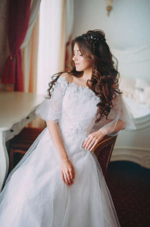 beautiful bride posing in a hotel on a chairの写真素材
