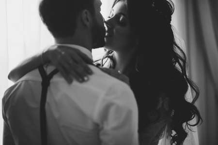 The groom and bride sitting against the background of a large window.の写真素材