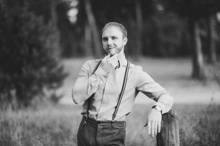 Hipster. Stylish groom with beard posing outdoors