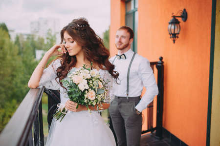 A stylish elegant bride and groom posing near the hotelの写真素材