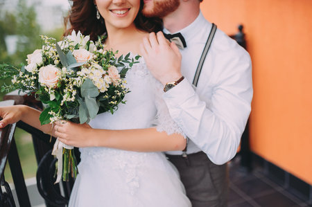 A stylish elegant bride and groom posing near the hotel