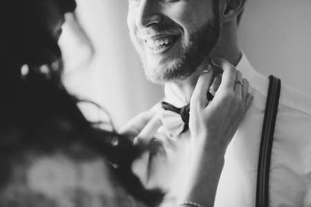 Attractive young bride adjusting the bow tie of her man.の写真素材