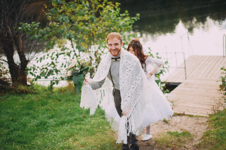 stylish bride and groom posing on the background of the river. funny photo