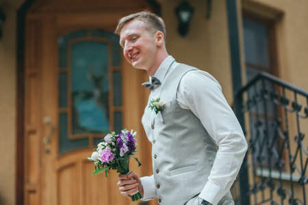 groom with wedding bouquet. Handsome groom at wedding tuxedo waiting for bride. Rich groom at wedding dayの写真素材