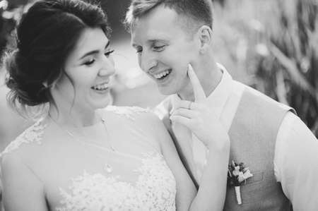 Beautiful wedding couple, bride,groom kissing and posing on the bridge near lakeの写真素材