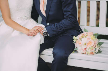 Close-up of grooms hand holding brides wirst tenderの写真素材