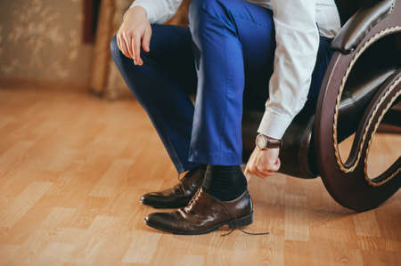 the groom wears shoes on wedding preparationsの写真素材
