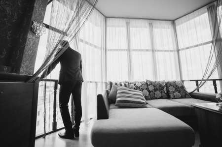 Grooms morning preparation, handsome groom getting dressed and preparing for the wedding, the groom wears a jacketの写真素材