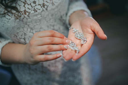 The bride corrects the earring, Beautiful earrings and hands of the brideの写真素材