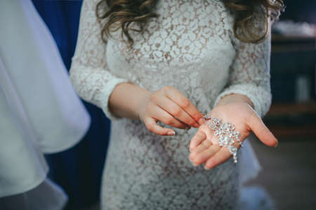 The bride corrects the earring, Beautiful earrings and hands of the brideの写真素材