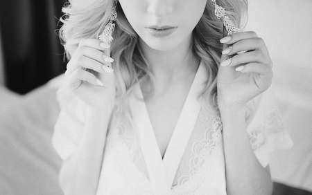 The bride corrects the earring, Beautiful earrings and hands of the brideの写真素材