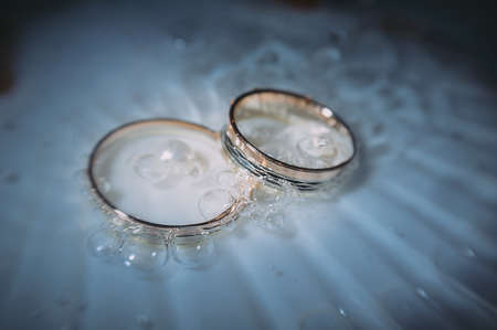 beautiful golden wedding rings on sparkling backgroundの写真素材