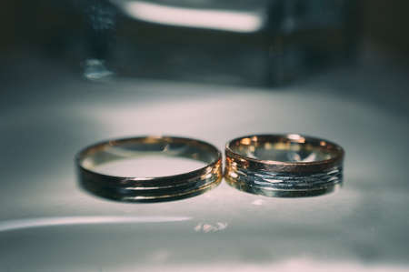 beautiful golden wedding rings on sparkling backgroundの写真素材