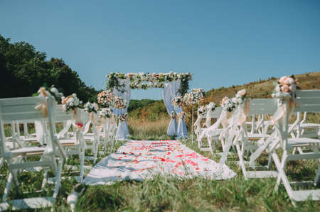 Wedding arch decorated with cloth and flowers outdoors. Beautiful wedding set up.Part of the festive decor, floral arrangement.の写真素材