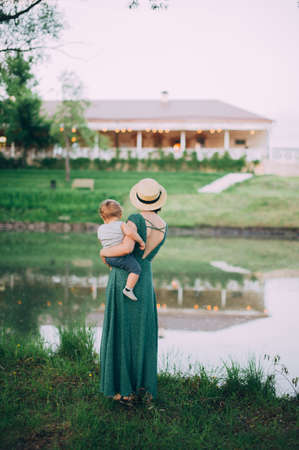 Happy mother with one year old baby on the background of ligh Lakeの写真素材