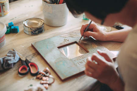 girl paints the frame with a brush. handwork. creationの写真素材