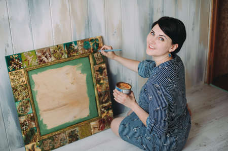 woman paints a mirror frame. handwork. hand madeの写真素材