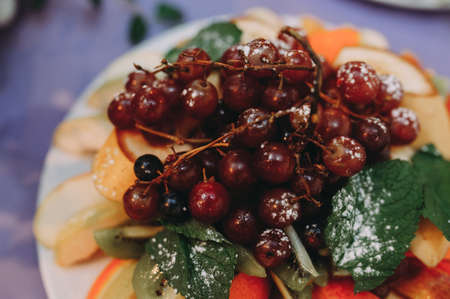 fruit-sliced plate. grapes, oranges, mint, icing sugarの写真素材