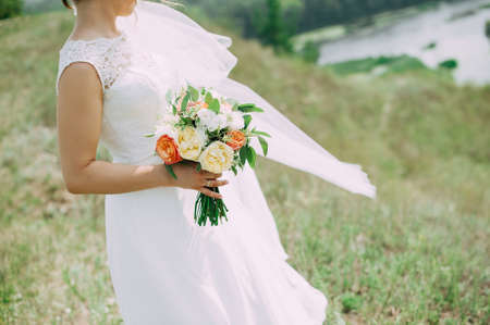 Beautiful wedding bouquet in hands of the brideの写真素材