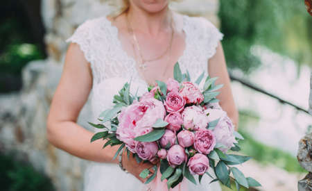 The bride with a bouquet on beautiful large lake background at sunset. Rustic Weddingの写真素材