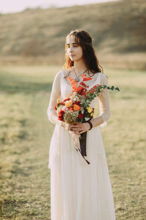 Beautiful bride with a stylish bouquet of different flowers. Rustic Styleの写真素材
