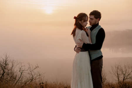 bride and groom at sunset. hugging. soft morning evening light. fog in the background. love. privacyの写真素材